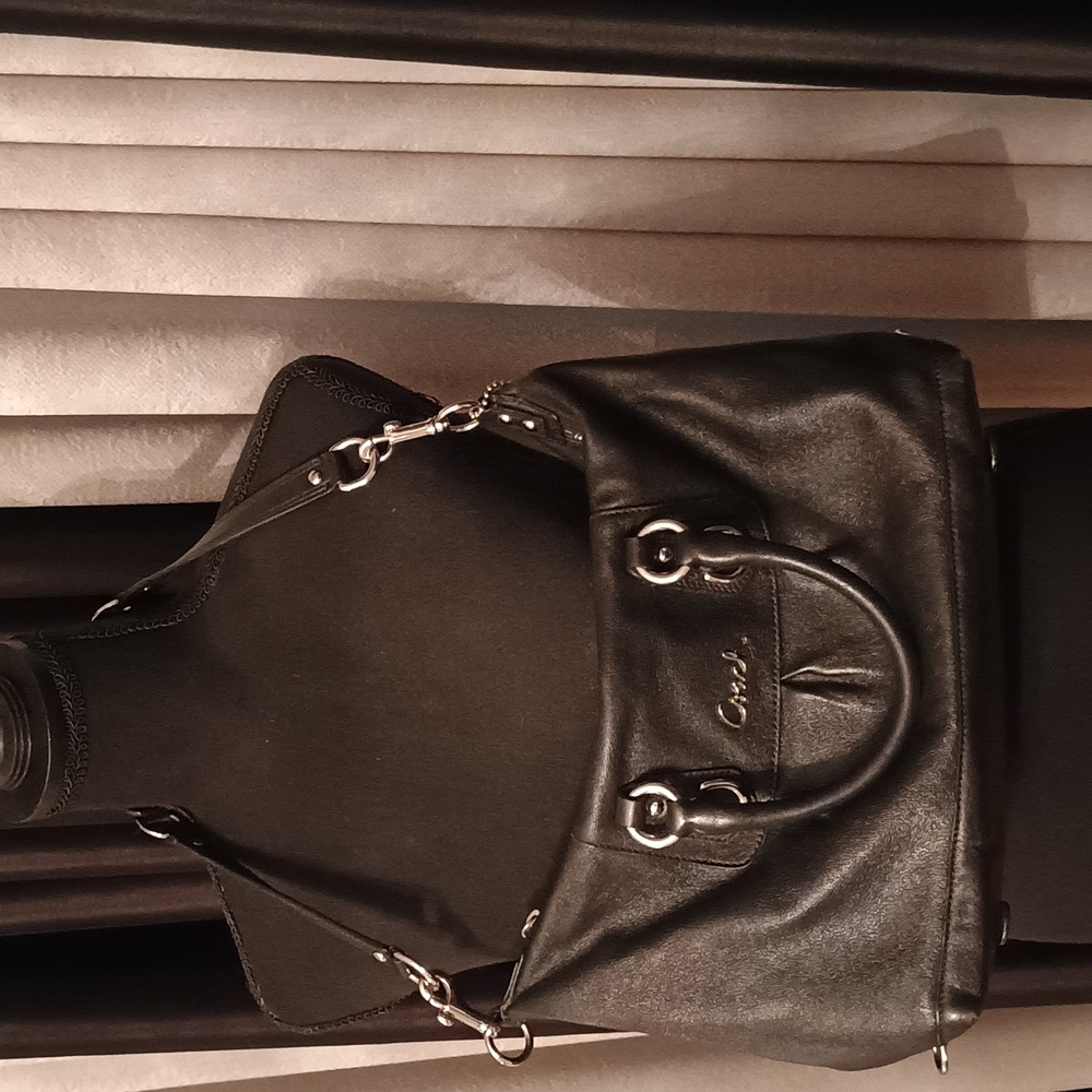 Coach black purse with handles and shoulder strap.